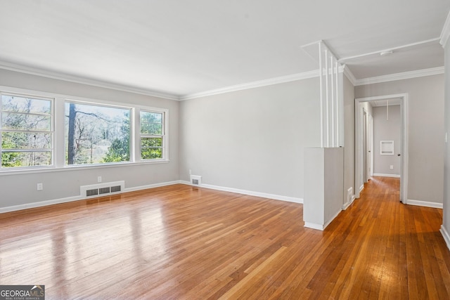 unfurnished room featuring light wood-style floors, baseboards, crown molding, and a smoke detector
