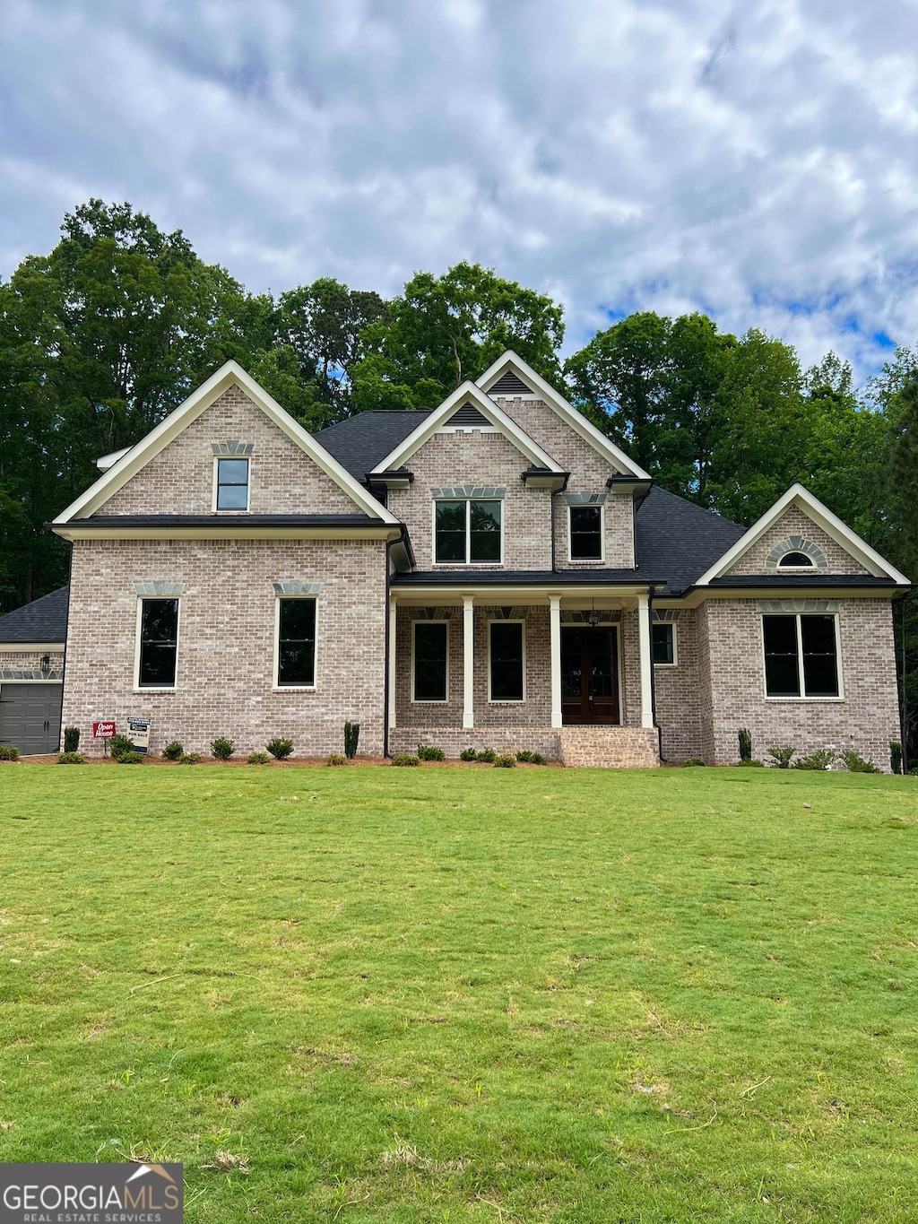 craftsman house featuring a front yard, brick siding, and covered porch