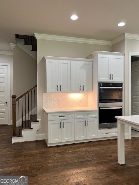 5907 SW Bunting Ln SW Unit 2, Atlanta, GA 30331 - kitchen with stainless steel double oven, crown molding, white cabinetry, recessed lighting, and dark wood-style flooring