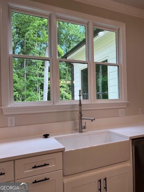 5907 SW Bunting Ln SW Unit 2, Atlanta, GA 30331 - kitchen view of white cabinets, light countertops, a sink, and dishwashing machine