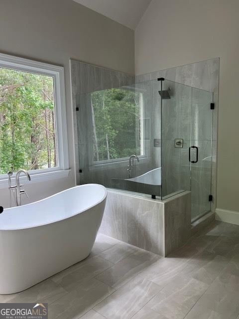 5907 SW Bunting Ln SW Unit 2, Atlanta, GA 30331 - full bath featuring a shower stall, a soaking tub, lofted ceiling, marble look tile flooring, and baseboards