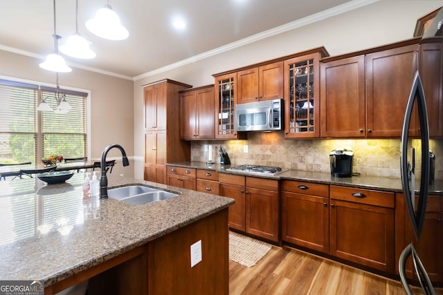 663 Warm Springs Ct, Loganville, GA 30052 - kitchen with stainless steel appliances, stone countertops, light wood-type flooring, brown cabinetry, and decorative light fixtures