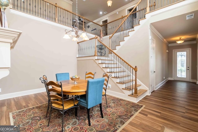663 Warm Springs Ct, Loganville, GA 30052 - dining area featuring ornamental molding, stairs, wood finished floors, a towering ceiling, and a chandelier
