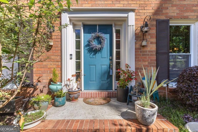 doorway to property featuring brick siding
