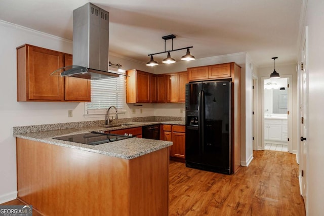 kitchen with black appliances, island range hood, a sink, a peninsula, and ornamental molding