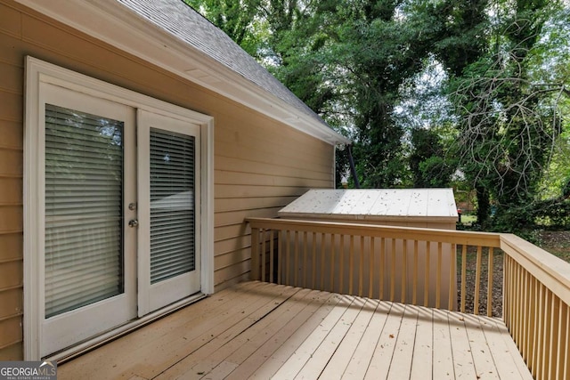 deck featuring view of wooded area and french doors