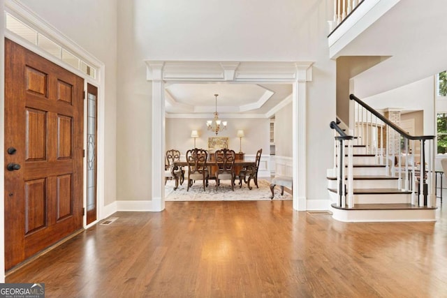 3456 Glen Mist Pl, Dacula, GA 30019 - entrance foyer featuring wood finished floors, stairway, a tray ceiling, a chandelier, and ornamental molding