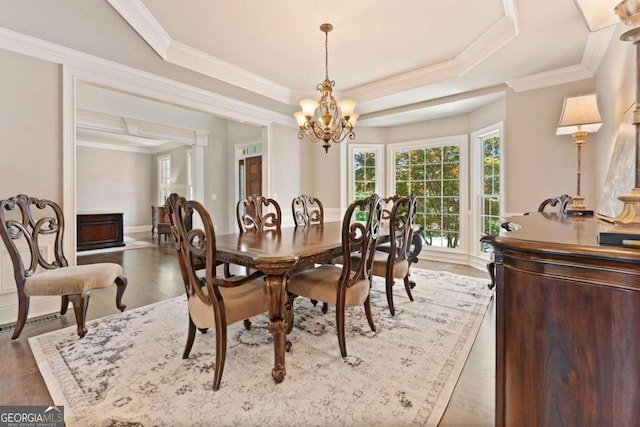 3456 Glen Mist Pl, Dacula, GA 30019 - dining room featuring a chandelier, wood finished floors, ornamental molding, and a raised ceiling