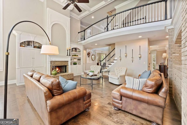 3456 Glen Mist Pl, Dacula, GA 30019 - living room with a fireplace, a towering ceiling, stairway, a ceiling fan, and wood finished floors