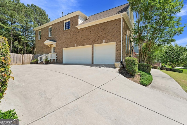 3456 Glen Mist Pl, Dacula, GA 30019 - view of side of property featuring driveway, brick siding, and an attached garage