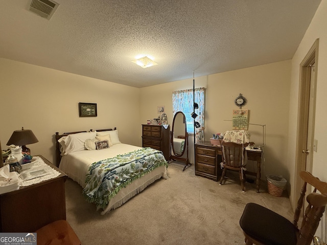 bedroom featuring light carpet and a textured ceiling
