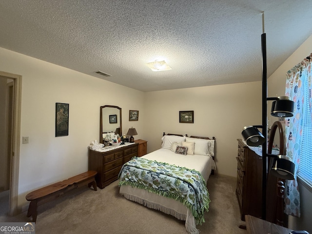 bedroom featuring light colored carpet and a textured ceiling