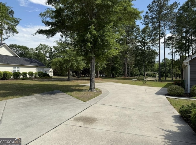 view of home's community with a yard and concrete driveway