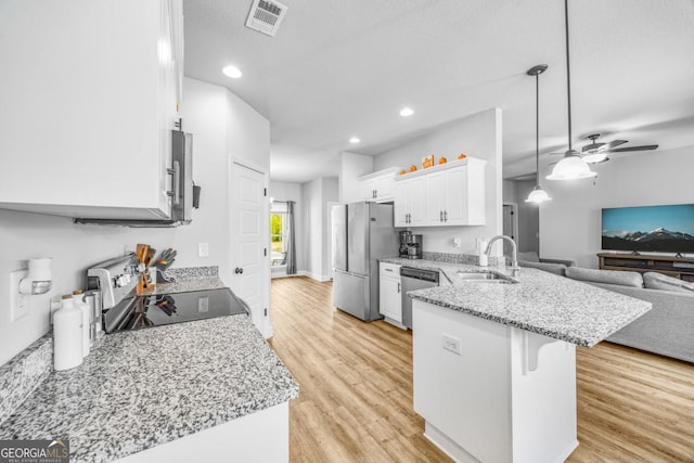 145 Gavin Way, Rincon, GA 31326 - kitchen with a sink, a peninsula, stainless steel appliances, open floor plan, and white cabinets