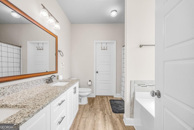 145 Gavin Way, Rincon, GA 31326 - full bathroom with wood finished floors, toilet, double vanity, a bath, and baseboards