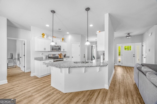 145 Gavin Way, Rincon, GA 31326 - kitchen with appliances with stainless steel finishes, a sink, a breakfast bar, a peninsula, and light wood finished floors
