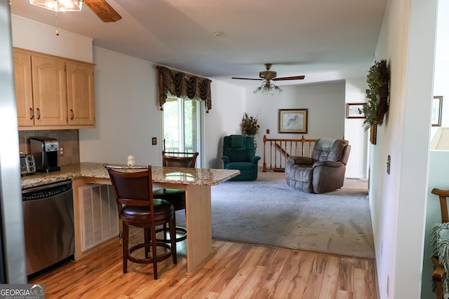 kitchen with stainless steel dishwasher, a ceiling fan, and light wood finished floors