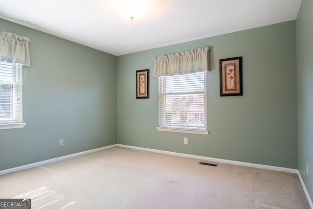 spare room featuring carpet and baseboards
