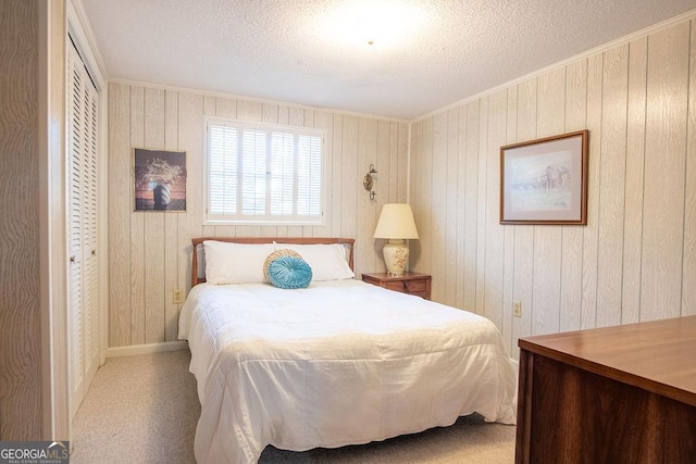 bedroom with a textured ceiling, ornamental molding, wooden walls, and baseboards