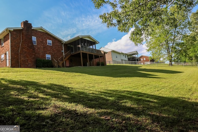 back of property featuring a chimney, stairs, a sunroom, brick siding, and a deck