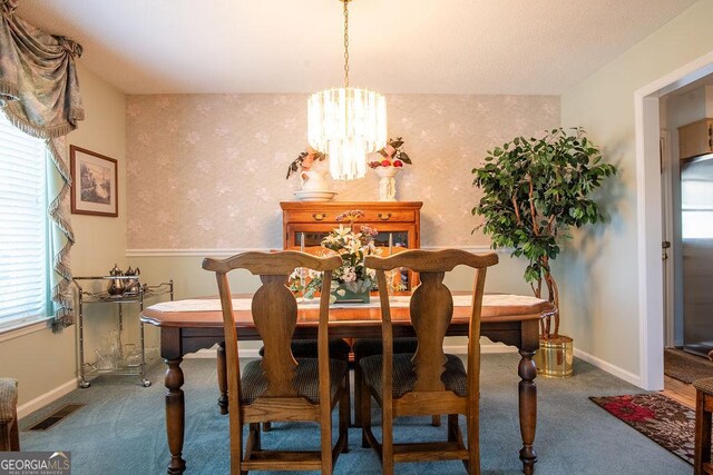 dining area featuring carpet, a chandelier, and baseboards