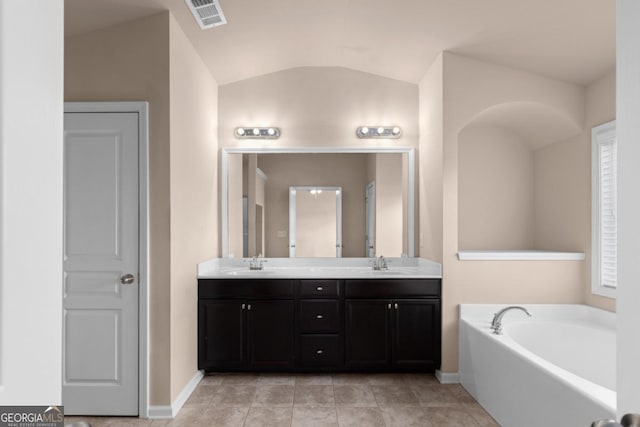 full bath with vaulted ceiling, double vanity, baseboards, and a garden tub