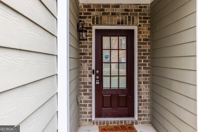 doorway to property featuring brick siding