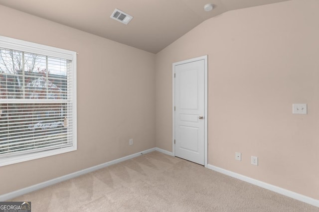 unfurnished room with lofted ceiling, carpet, baseboards, and a smoke detector