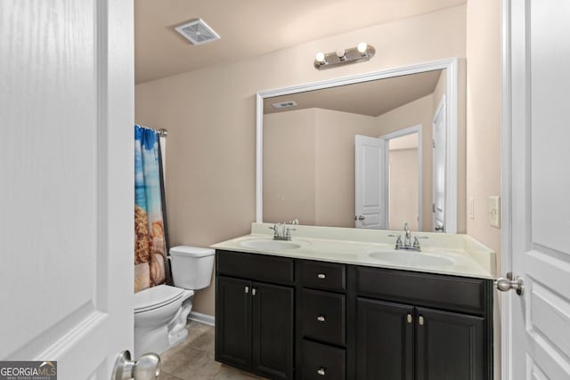 bathroom featuring toilet, double vanity, and tile patterned floors