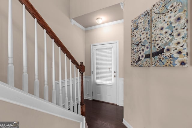 entryway with crown molding, wood finished floors, a wainscoted wall, stairway, and a decorative wall