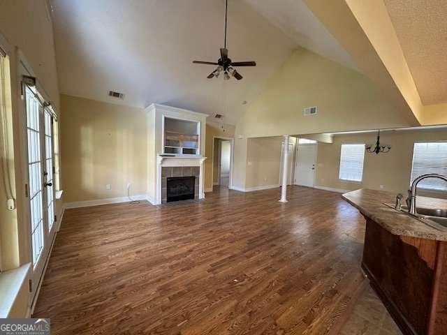 2506 Wateringhole Ct, Statesboro, GA 30458 - unfurnished living room featuring a sink, high vaulted ceiling, ceiling fan, a tile fireplace, and dark wood finished floors