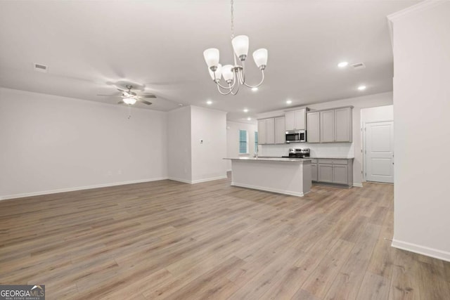 kitchen featuring stainless steel appliances, open floor plan, a ceiling fan, recessed lighting, and a chandelier