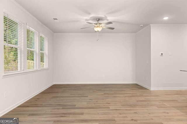 empty room with ceiling fan, crown molding, wood finished floors, baseboards, and recessed lighting