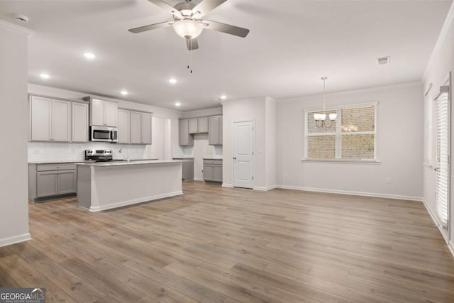 kitchen featuring appliances with stainless steel finishes, gray cabinetry, ceiling fan, a chandelier, and tasteful backsplash