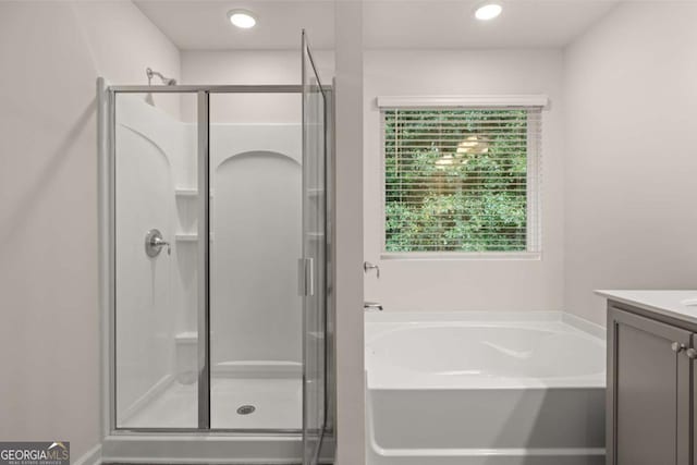 bathroom featuring a stall shower, a bath, vanity, and recessed lighting