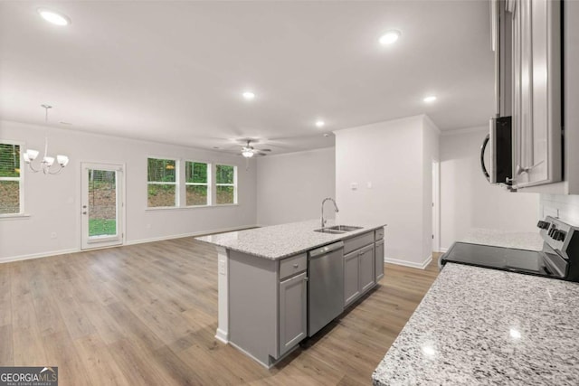 kitchen featuring appliances with stainless steel finishes, a sink, gray cabinetry, ceiling fan, and open floor plan