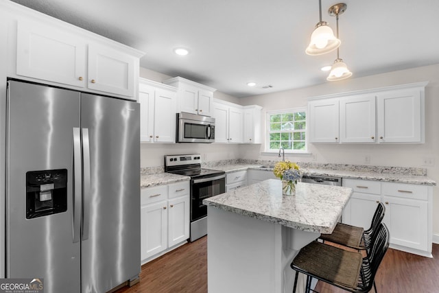 kitchen with appliances with stainless steel finishes, white cabinets, dark wood-style flooring, a sink, and recessed lighting
