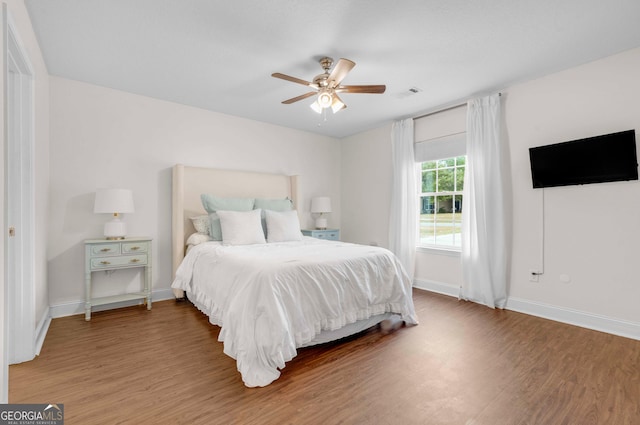 bedroom with wood finished floors, baseboards, and a ceiling fan