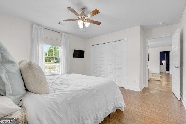 bedroom with light wood-style floors, baseboards, a closet, and a ceiling fan