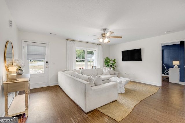 living room featuring wood finished floors, ceiling fan, and baseboards