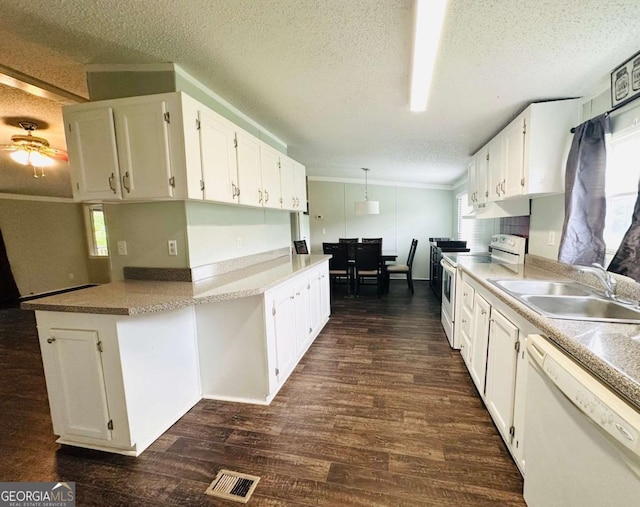 kitchen featuring white appliances, a sink, dark wood finished floors, ornamental molding, and white cabinetry