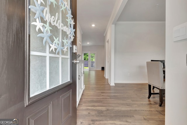 foyer with crown molding, baseboards, wood finished floors, and recessed lighting