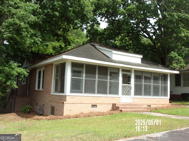 view of front of house featuring crawl space, a sunroom, a front yard, and entry steps