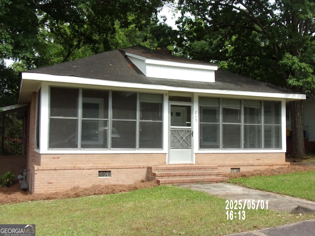 view of front of home featuring crawl space, entry steps, a sunroom, and brick siding