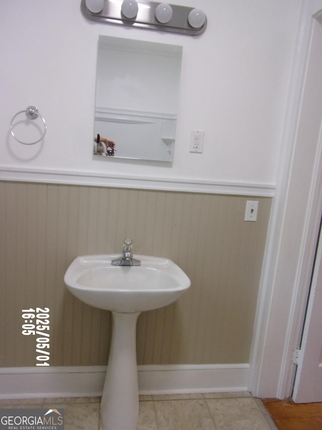 bathroom featuring wainscoting and a sink