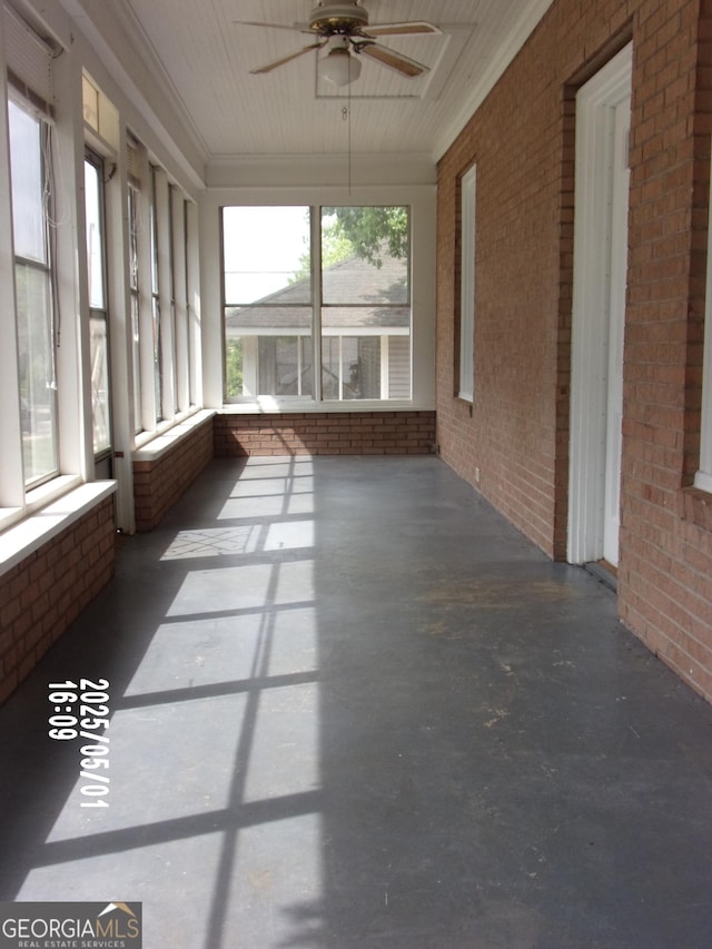 unfurnished sunroom featuring a ceiling fan