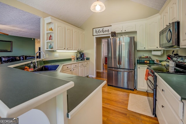 637 Lakeview Dr, Newborn, GA 30056 - kitchen with appliances with stainless steel finishes, a sink, a textured ceiling, lofted ceiling, and light wood-style flooring