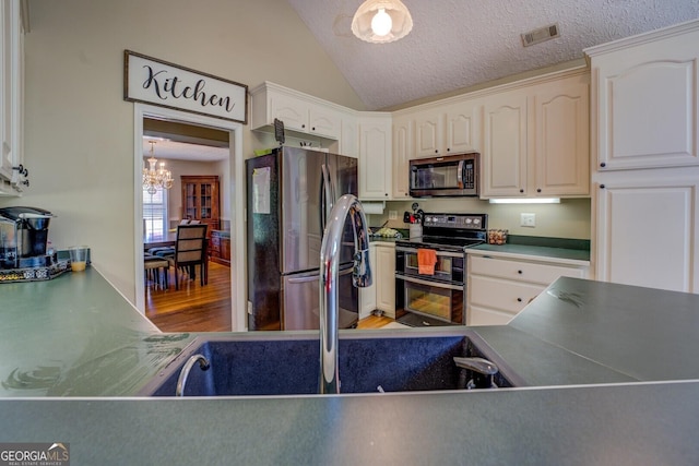 637 Lakeview Dr, Newborn, GA 30056 - kitchen with appliances with stainless steel finishes, a chandelier, wood finished floors, vaulted ceiling, and white cabinetry