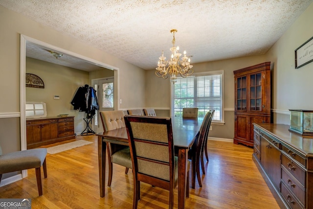 637 Lakeview Dr, Newborn, GA 30056 - dining room with light wood-style flooring, a chandelier, and a textured ceiling