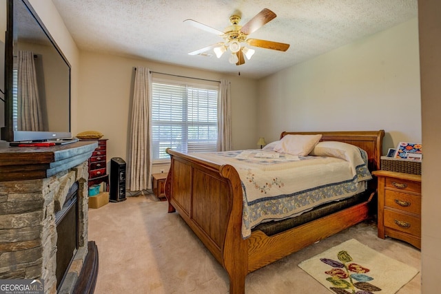 637 Lakeview Dr, Newborn, GA 30056 - bedroom with light colored carpet, a stone fireplace, a textured ceiling, and a ceiling fan